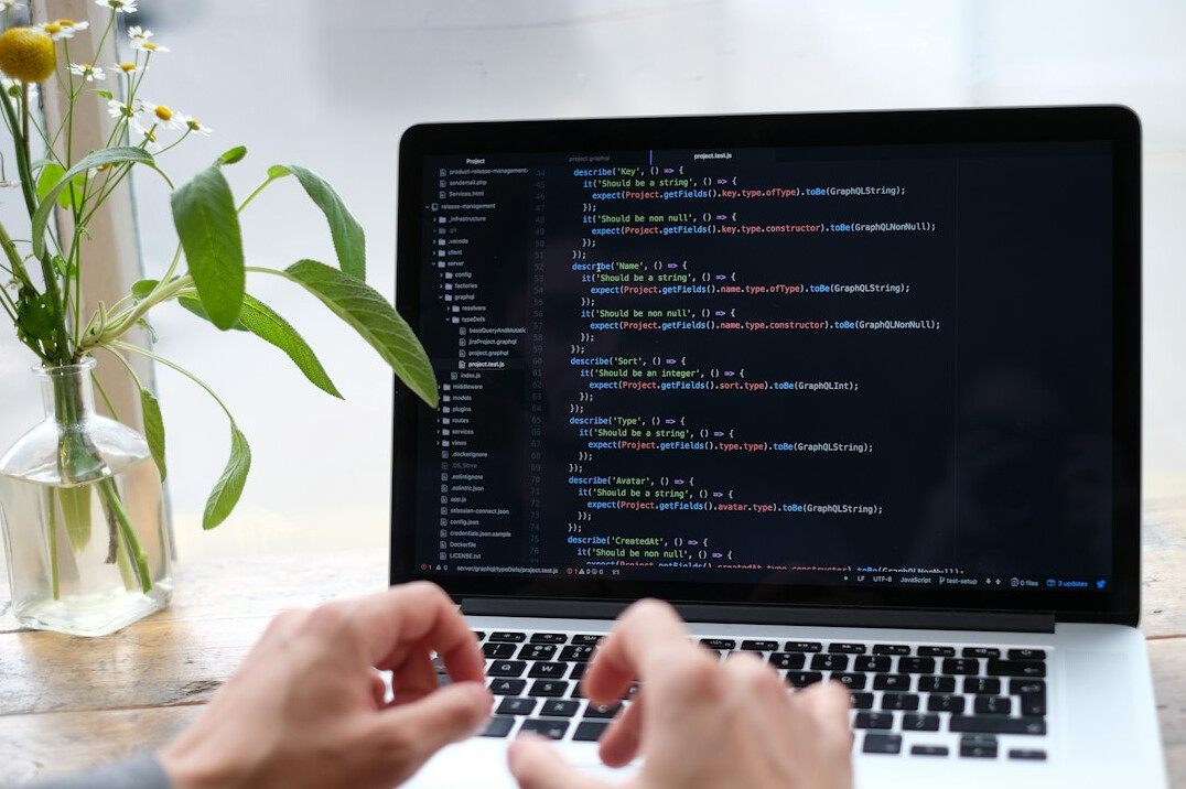 person coding on laptop